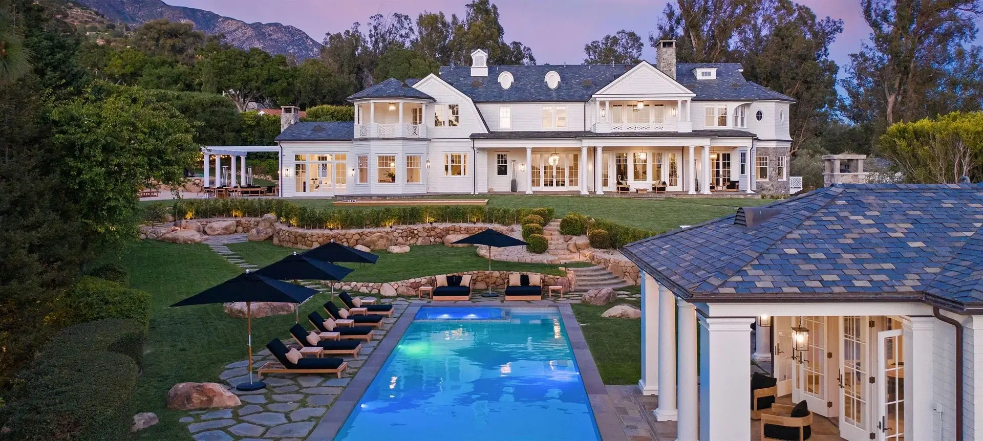 A large white house with a pool in the middle of it.